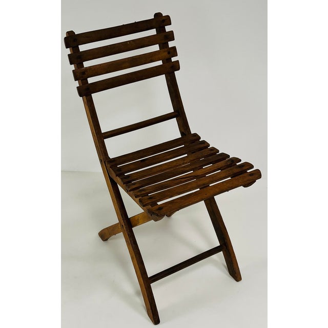 A rare ensemble of four antique French folding chairs, expertly crafted from solid oak. Each chair features a gracefully...