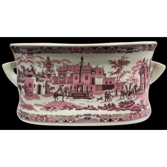 This is a large scale pink transferware footbath. It is a heavy ceramic piece. It has Victorian England styling, and the...