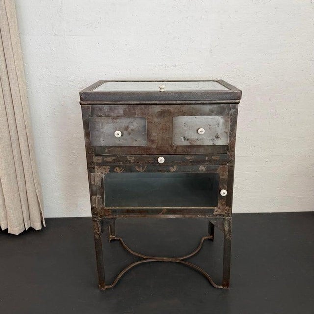 This industrial, brushed steel and glass, medical apothecary cabinet is a handsome storage piece that can serve a...