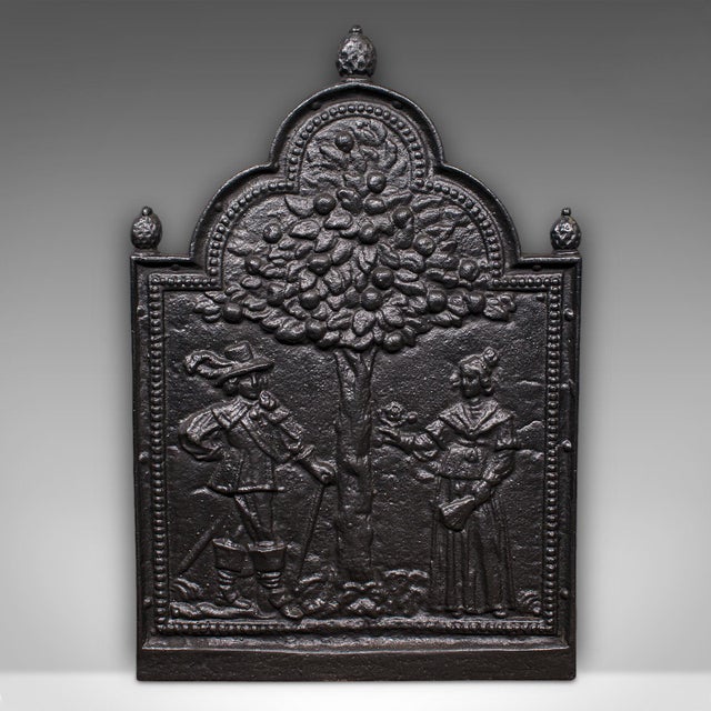 This is an antique decorative fire back. An English, cast iron figural fireplace reflector, dating to the late Victorian...