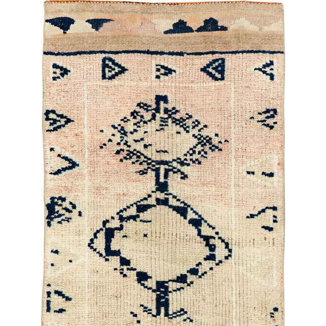This mid-20th-century Turkish Anatolian runner presents a spare, highly graphic composition on a warm ivory and pale beige...
