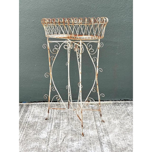 This vintage plant holder is an airy, sculptural composition of hand-bent iron wire, with a long oval planter basket...