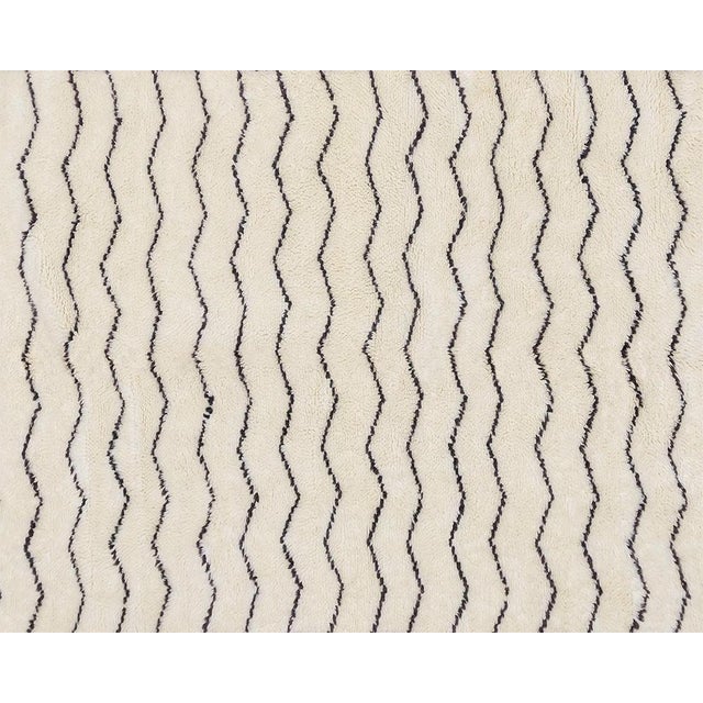 Sophisticated hand-knotted wool rug with crisp Chevron patterns in Charcoal on an Ivory base, creating a timeless and...