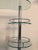 Mid Century Modern chrome and glass dry bar. Having three-tiers for bottles and glassware. Along with a curved glass top.