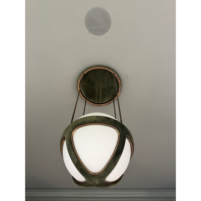 This unique Apparatus Pendant in Juniper Suede and Aged Brass (Waxed) finish and armature with a mold blown glass orb is...