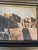 An original oil, likely on canvas board: a multi-storey stepped adobe pueblo with wooden ladders and a kiva ladder in the...