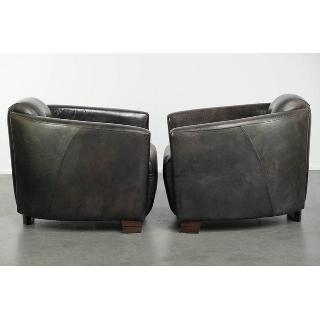 This vintage set of 2 armchairs is made of black grained cowhide leather in an Aviator design and features a comfortable...