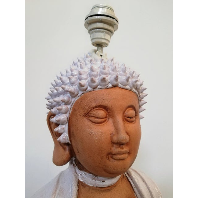 Great sculptural lamp of Asian origin and datable between the 1960s and the 70 depicting Buddha lying on a lotus flower....