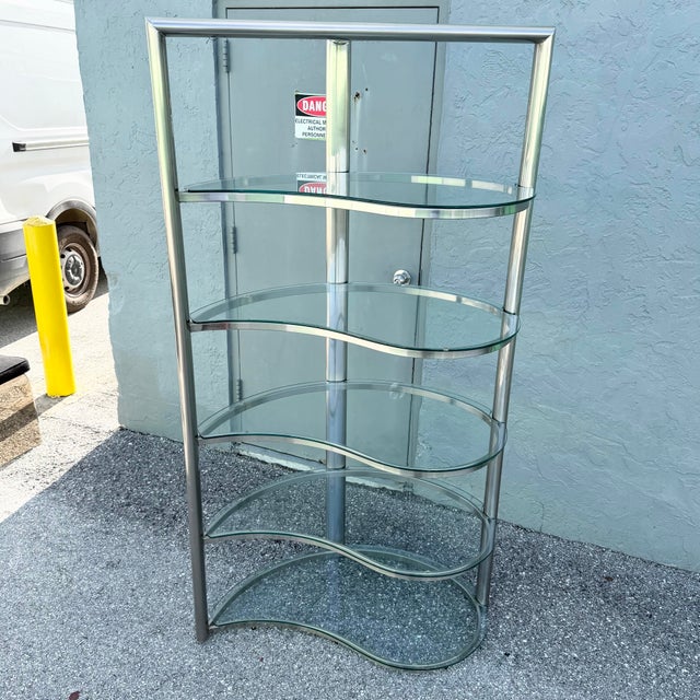 A striking Postmodern étagère that blends sculptural form with sleek contemporary materials. Constructed from a brushed...