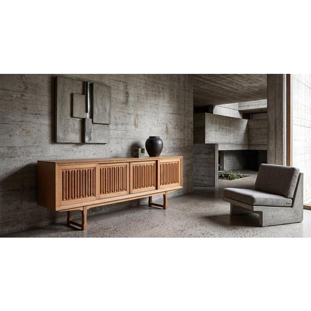 Elegant Danish low sideboard from the 1960s, attributed to Henning Kjærnulf. Crafted in solid oak, the piece features a...