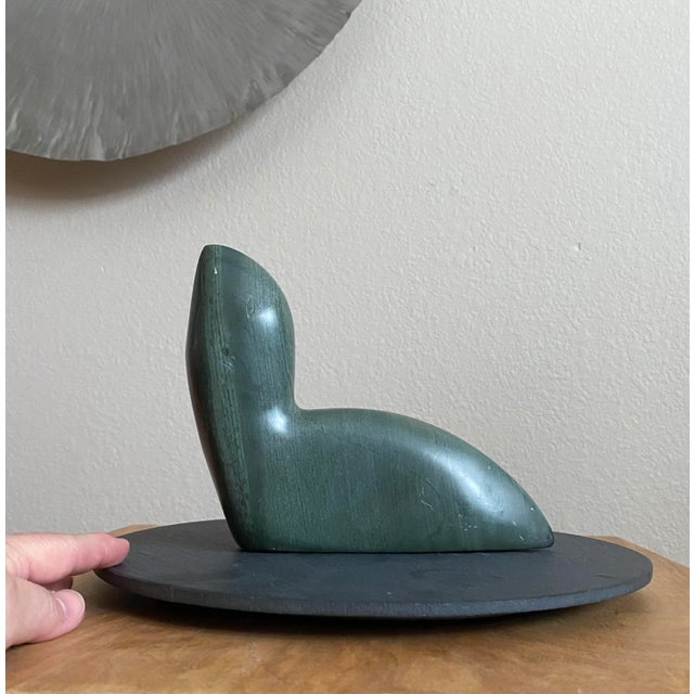 This exquisite Inuit carved stone sculpture features a beautifully detailed seal, masterfully crafted from a solid piece...