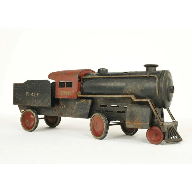 This original toy train engine features a steel body in red and black paint with rubber wheels that function well. Made by...