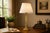 Neoclassical brass table lamp dating to the 1930s. A fluted column and ornate Corinthian-style capital rise from a stepped...