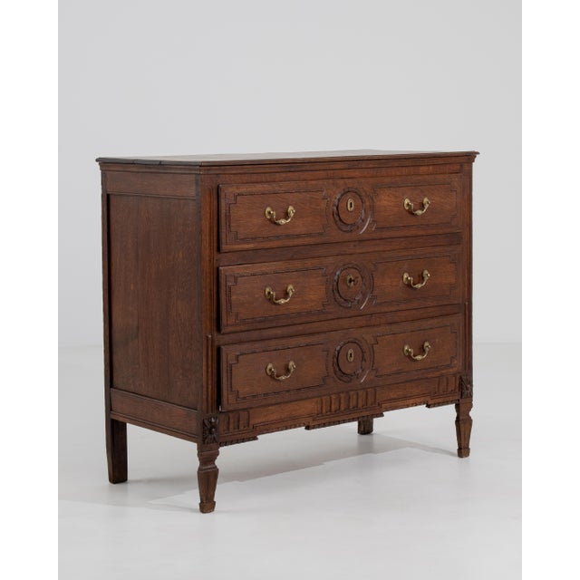A Louis XVI chest of drawers featuring straight lines and classical detailing. The piece includes a rectangular case with...