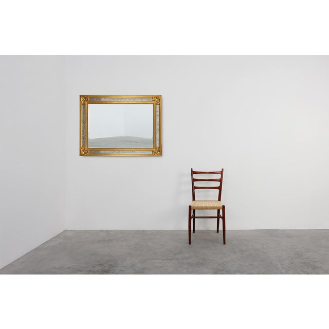 Originating from mid-century Belgium, this substantial Neoclassical or Baroque-inspired mirror by the high-end...