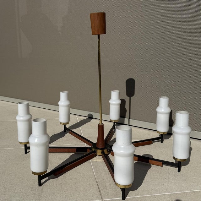 Elegant Scandinavian Modern chandelier from the 1960s featuring a refined combination of teak wood, black lacquered metal,...