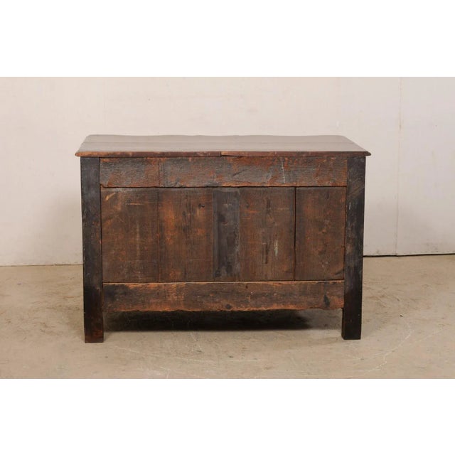 A French period rococo serpentine chest of drawers from the 18th century. This antique commode from France features a...