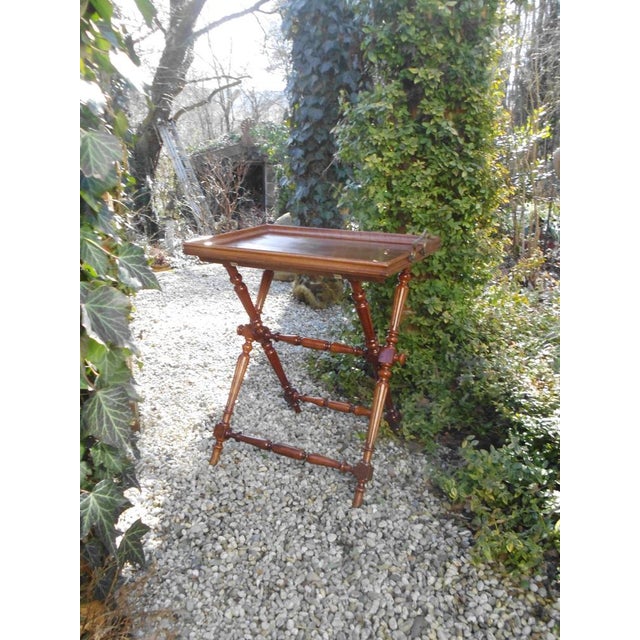 An antique side table with a removable tray; a charming detail is the original fish-shaped handles. The wood has been...