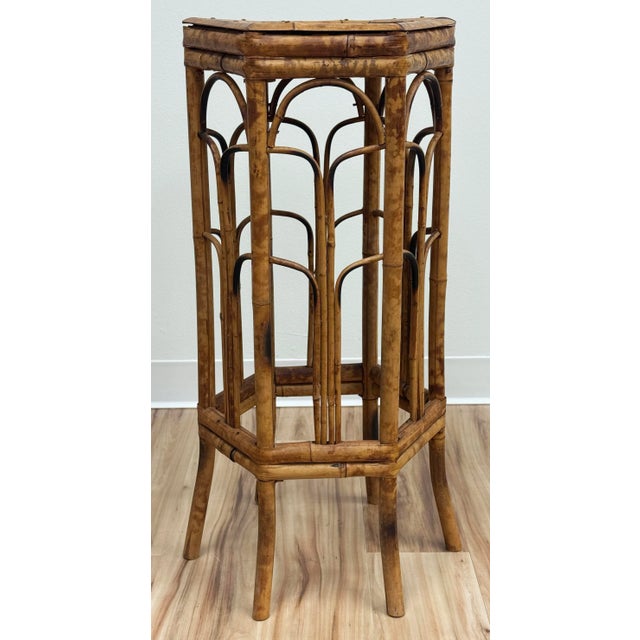 Tall bamboo plant stand with rich burnt tortoise shell finish. Hexagonal shape with bent reed base detail. Top measures...