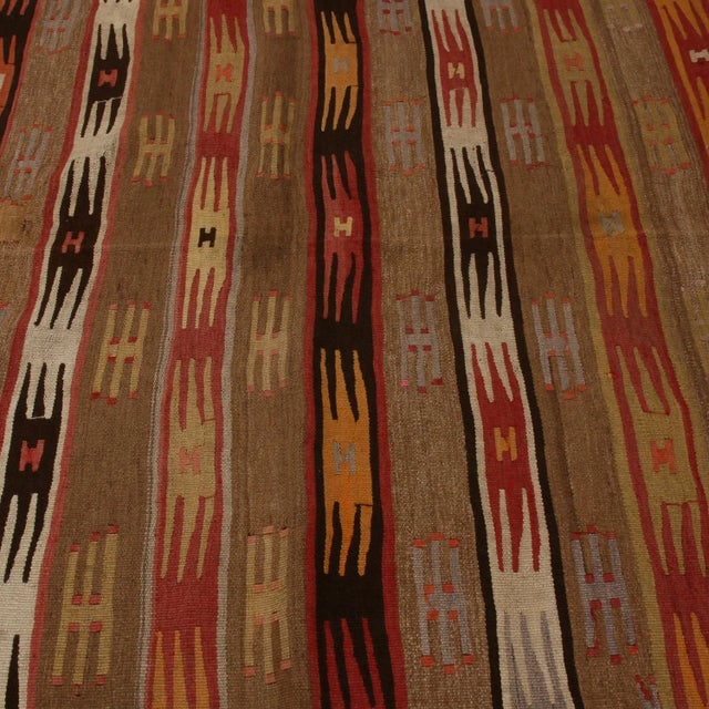 Flat-woven in high-quality wool originating between 1940-1950, this vintage geometric wool Kilim rug enjoys its own...