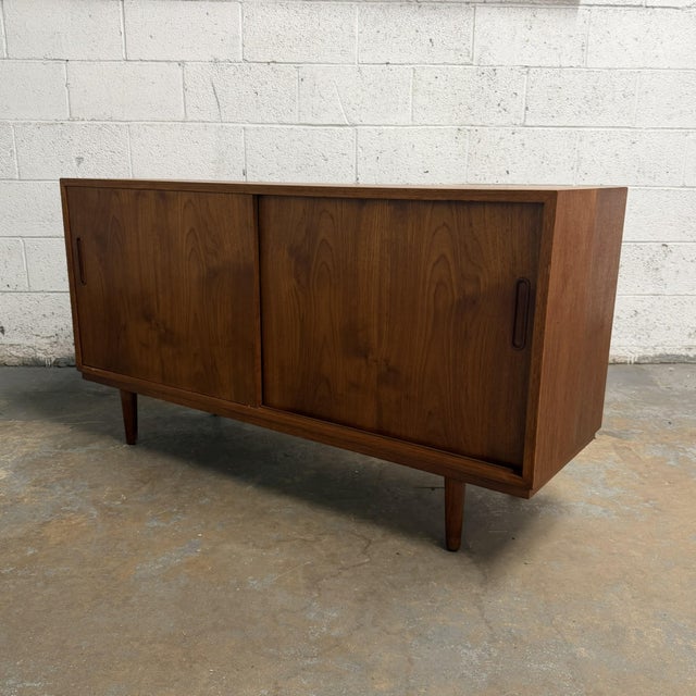 A compact Danish teak cabinet designed by Carlo Jensen for Poul Hundevad, dating to the 1960s. The cabinet has a clean,...