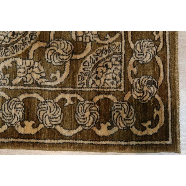 This brown earth tone wool rug features a durable hand knotted pile construction. Designed in the Baluch style, it...
