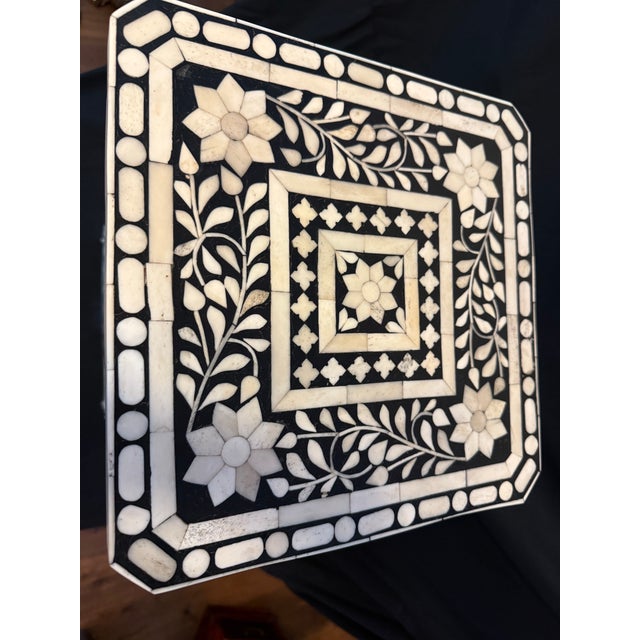 Stunning vintage handcrafted bone inlay accent table featuring intricate white floral and vine motifs on a dramatic black...