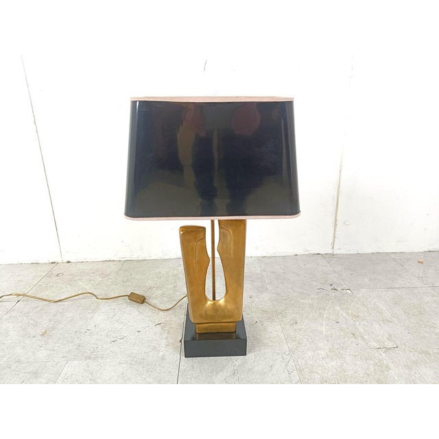 Sculptural brass table lamp in the manner of Alain Chervet. Beautfully sculpted brass base with a golden and black lamp...