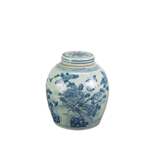A beautiful blue and white finished porcelain ginger jar with the hand painted birds and blooming flowers. This lidded jar...