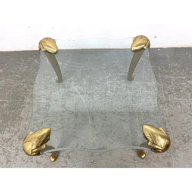 Rare vintage side table in the style of P.E. Guerin, featuring sculpted frond-style legs and a thick round glass top. The...