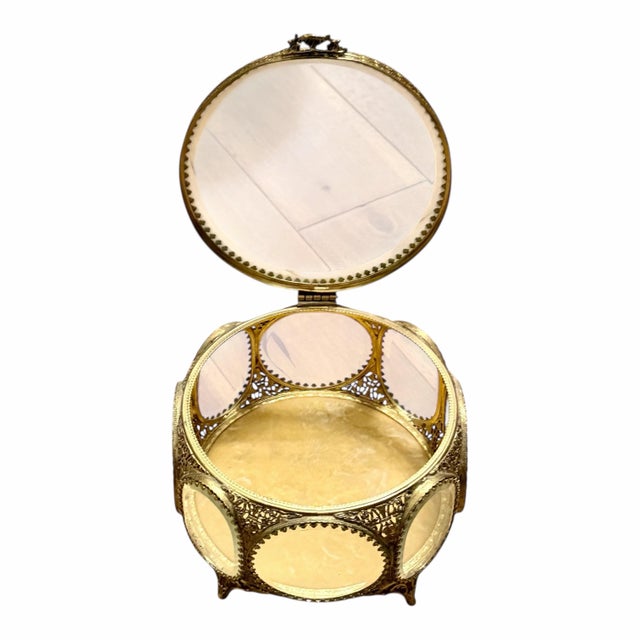 Elegant vintage ormolu and glass vitrine featuring a pierced gilt metal frame with rococo-inspired detailing and curved...