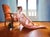 The Orange Voltaire I by Linda Delahaye | Oil on panel Nude woman lounging beside an orange chair. For Sale