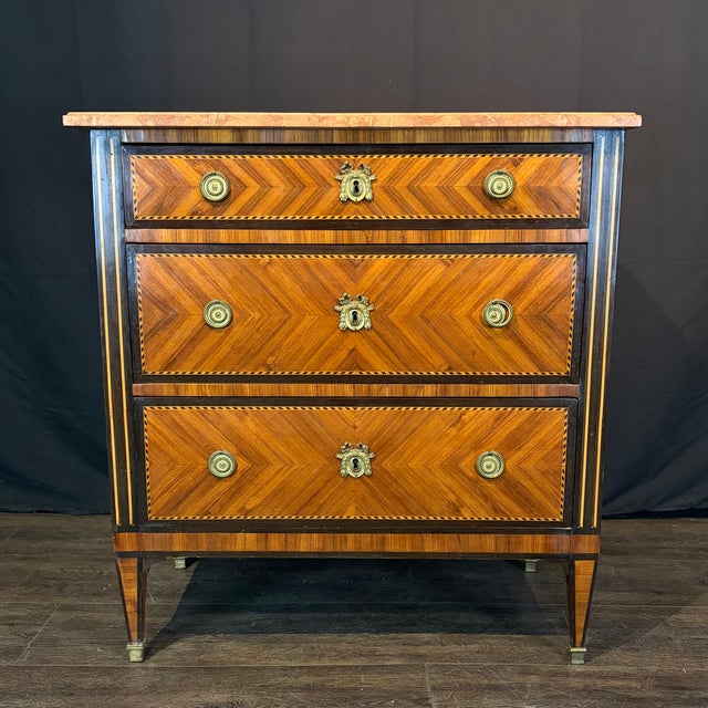 Antique French marble top commode having striking chevron parquetry veneers framed by contrasting king wood banding and...