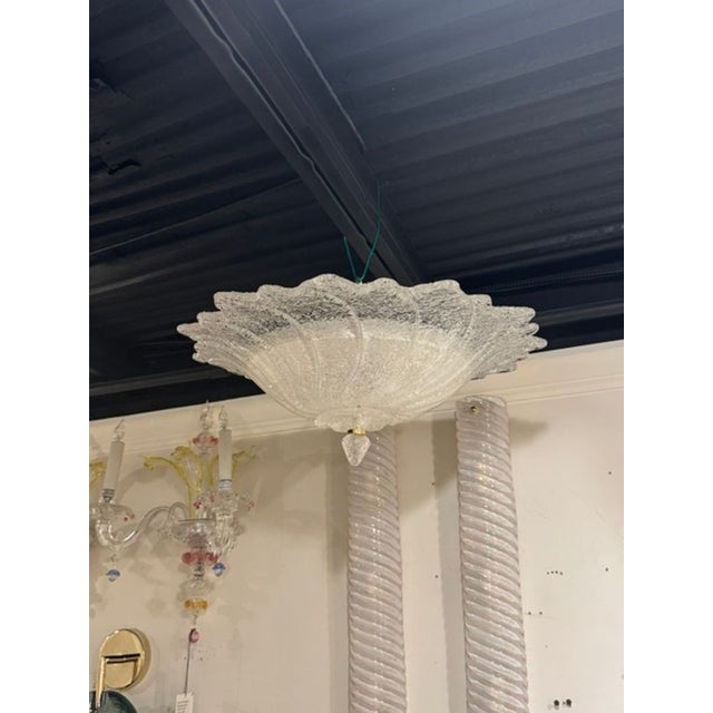 The Murano Granola Glass Clear Wave Flush Mount is a stunning ceiling fixture that adds a touch of elegance to any room....