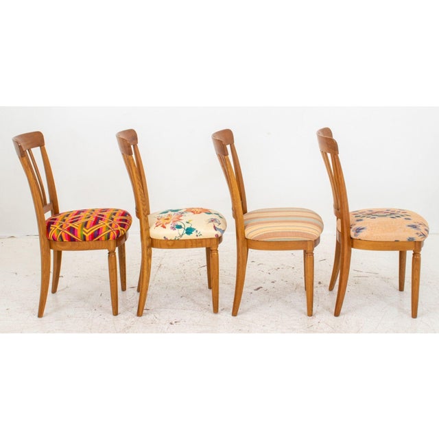 Set of Four Country Oak Dining Chairs, each with shaped crest rail, spindles, and shaped upholstered seat (each seat in...