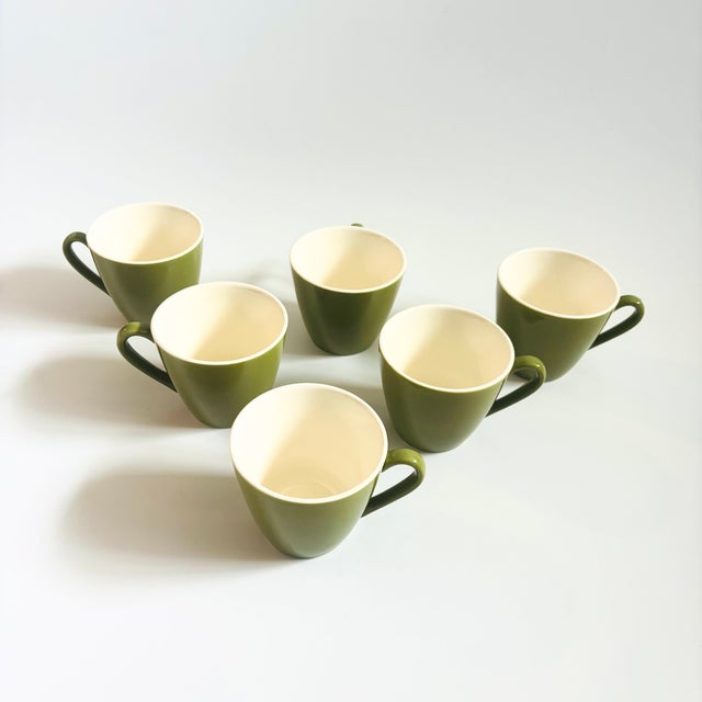 A lovely set of 6 vintage pottery mugs. White interiors with a green exterior glaze. Each measures 4.5"W x 3.5"D x 3"H