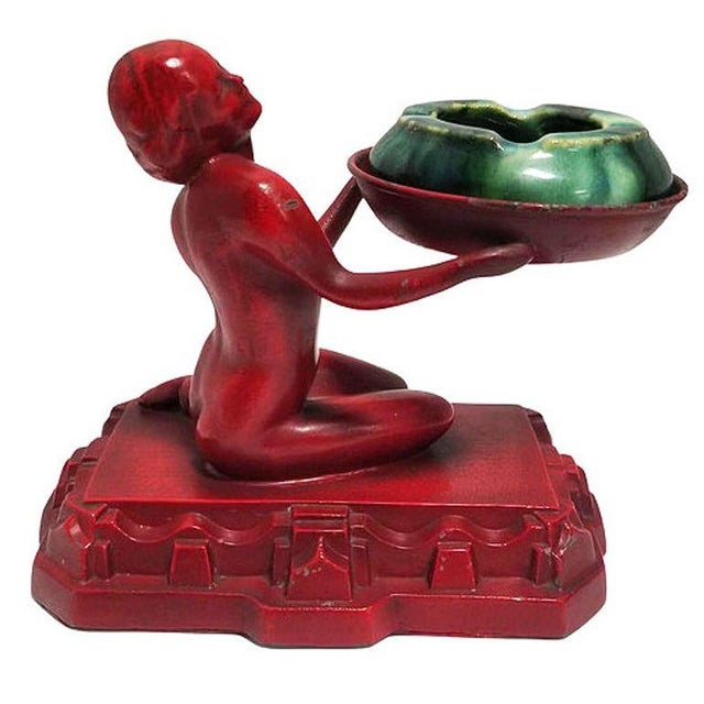 Rare 1920 figural ashtray by Nuart featuring striking red enameled metal nude female figurine seated atop an...