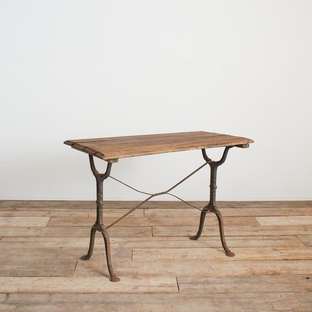 A fantastic original late 19th century French iron bistro table retaining its original wooden top and stunning wrought...