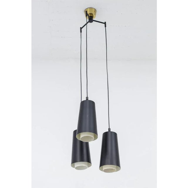 Trippel pendant lamp produced in Sweden by Luco. Made during the 1950s. Made from lacquered aluminum and steel. Brass...