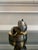 A contemporary still-life bronze of a fig, opened to reveal its seeded interior, with a single segment resting at its side...