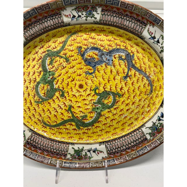 Chinese, early to mid 19th century. An antique famille jaune platter decorated with 3 imperial dragons chasing the central...