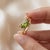 Infuse vibrant color into your look with this eye-catching bypass ring starring a lively marquise-cut Peridot. The...