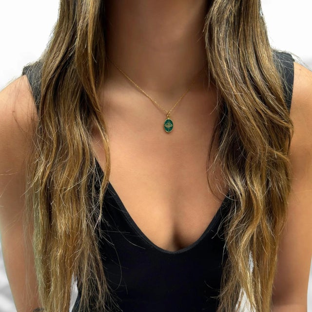 Green Enamel Evil Eye Minimalist Gold Protective Necklace is a chic and symbolic accessory that seamlessly combines...