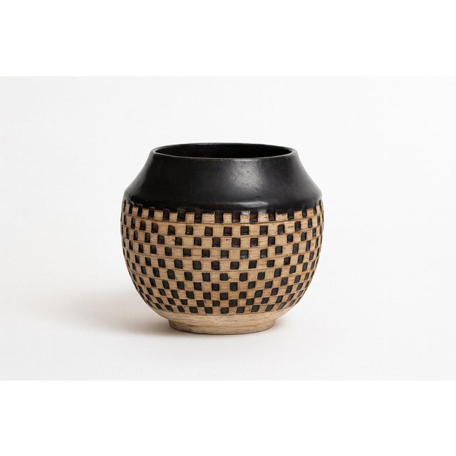 A hand-thrown ovoid vessel by New York potter Walter Yovaish, crafted in stoneware with minimalist design. The smooth tan...