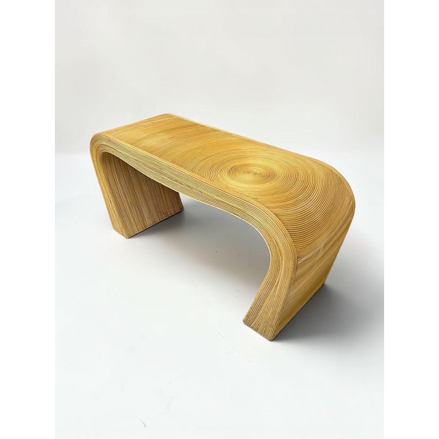 A striking vintage pencil reed waterfall console table showcasing the timeless elegance of 1970s Organic Modern design,...