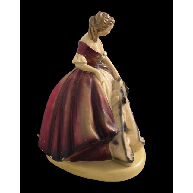 A striking mid-century figural ceramic table lamp featuring two Borzoi (Russian Wolfhound) dogs, sculpted as part of an...