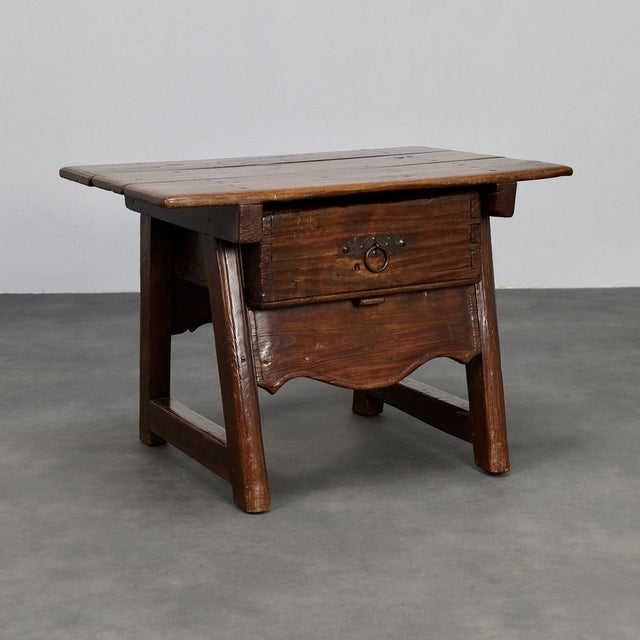 This 18th-century wooden side table carries the quiet dignity of time, its surface enriched with a beautiful patina that...