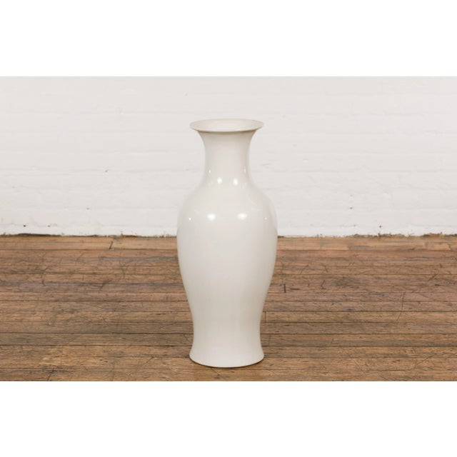 A Chinese vintage blanc de Chine altar vase from the mid 20th century, with flaring neck. Experience the timeless elegance...