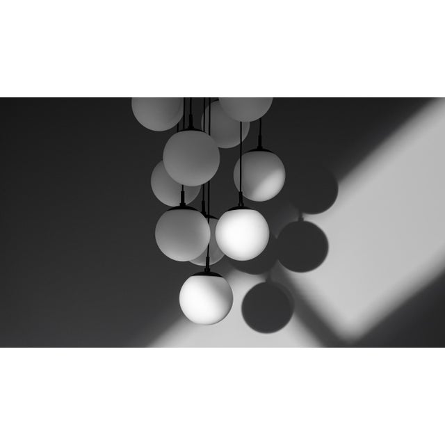 Here's the revised description: Globe Cluster Chandelier A 10-light cascading chandelier featuring hand-finished glass...