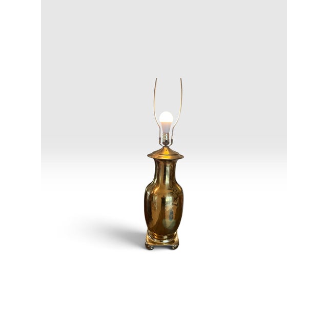 Elegant vintage polished brass table lamp featuring a substantial urn-form body with a beautifully reflective golden...